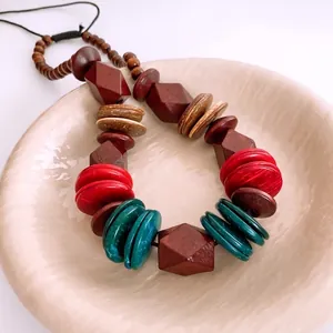 Bohemian beaded necklace featuring dark wood beads and colorful resin disks on a tray