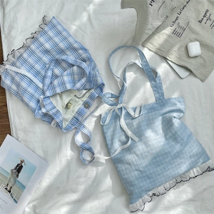 Detail of blue plaid canvas tote bags with white lace trim and bow knot decoration