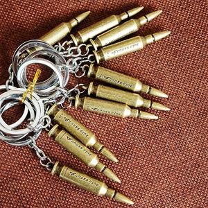 Brass bullet-shaped keychain with Cross Fire engraving and silver metal ring chain