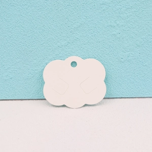 Cloud-shaped white paper earring display card with pre-cut slots on light blue surface