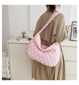 Detail of pink quilted puffer hobo bag with large capacity and minimalist strap