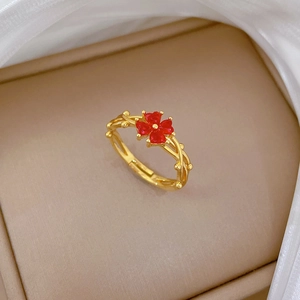 Détail de la bague trèfle doré avec pierre rouge et anneau réglable tressé