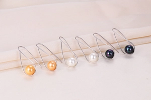 Detail view of S925 silver pearl drop earrings in gold, white, and iridescent black finishes