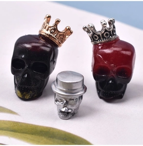 Close-up of assorted Halloween skull charms with crowns and hats for DIY jewelry