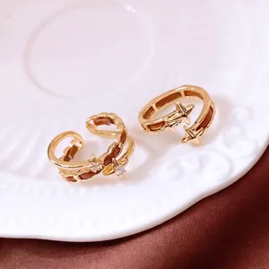 Luxury gold star open rings with brown leather inlay and zircon on a ceramic plate