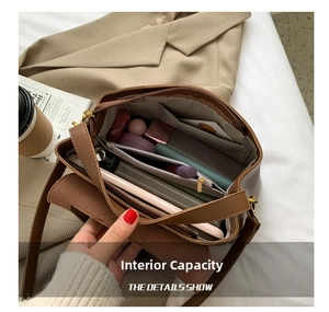 Detail view of large capacity brown leather shoulder bag interior with compartments