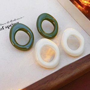 Close-up of retro resin oval hoop earrings in dark green and cream white colors