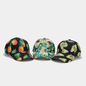Detailed view of three baseball caps featuring pineapple, avocado, and tropical fruit patterns