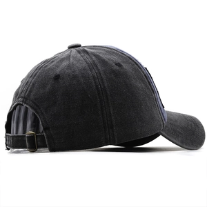 Dettaglio della fibbia in metallo e del patchwork blu sul cappellino in denim lavato