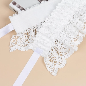 Detail of white floral lace elastic belt featuring intricate hollow patterns and satin ribbon
