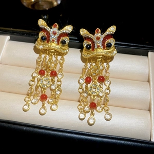 Vue macro de boucles d'oreilles lion doré avec émail et glands de pièces en cuivre