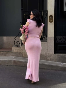 Detailed back view of pink knit two-piece set with ruffled top and midi skirt on street