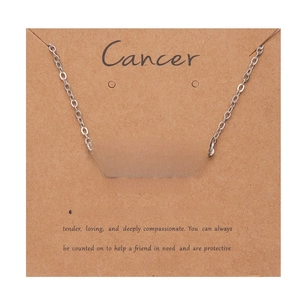 Macro shot of silver Cancer zodiac necklace on card showing fine chain and Old English font