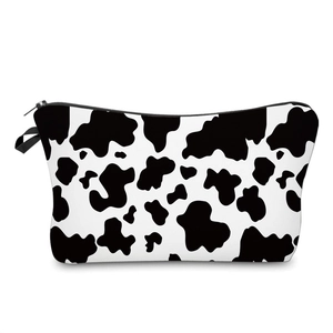 Trapezoidal makeup bag with black and white cow print and sturdy zipper closure