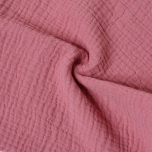 Macro detail of breathable double-layer cotton gauze fabric in dusty rose with soft texture