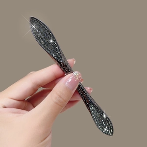 Macro shot of gun-grey alloy eye cream massager handle with pave-set grey rhinestones