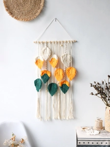 Detail of bohemian woven tapestry featuring cotton feathers in beige, yellow, and dark green