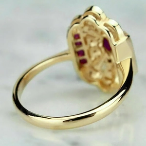 Détail macro d'une bague vintage dorée montrant les incrustations de pierres rouges
