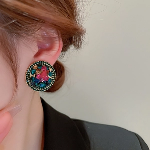 Detailed view of vintage round clip-on earrings with colorful rhinestones in gold setting