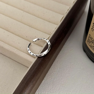 Close-up of a 925 sterling silver wavy band ring with vintage black star patterns