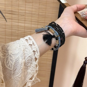 Close-up of bohemian multilayer beaded bracelet with tassels and crystal beads on a wrist