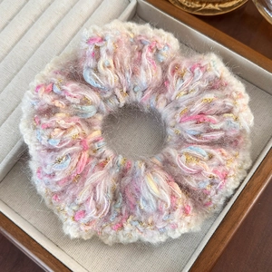 Detailed view of a soft knit scrunchie with pink and blue yarn in a velvet jewelry box