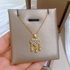Macro shot of gold-plated ruyi lock necklace with white zircon pavé and dangle beads