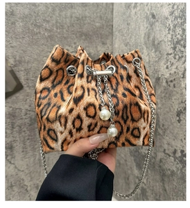 Detail of leopard print bucket bag with dual pearl charms and silver metal chain strap