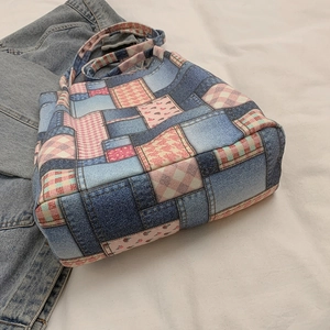 Blue denim patchwork tote bag with pink patterns shown in a flat lay casual lifestyle setting