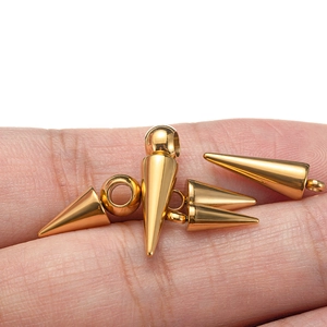 Pendentifs cônes en acier inoxydable doré pour bijoux sur le bout du doigt, fond blanc