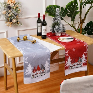 Detailed view of festive Christmas table runners with cartoon gnomes and snowflake prints