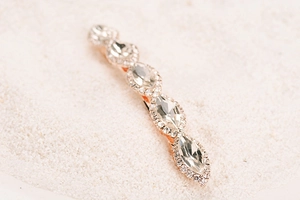 Macro detail of rose gold barrette featuring marquise crystals and round pavé rhinestones