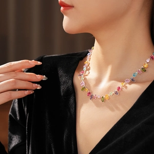 Detail of colorful gemstone necklace with mixed-cut stones on a black velvet dress