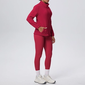 Dettaglio del set yoga in pile rosso con giacca con zip e leggings coordinati