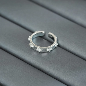 Macro shot of silver ring featuring brushed metal texture and zircon inlay details