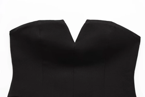 Dettaglio dello scollo a V profondo su un top a fascia nero con trama tessuta