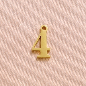 Detailed view of a gold-plated stainless steel number 4 pendant with polished finish