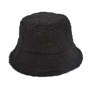 Detailed texture of black faux lamb wool bucket hat with soft sherpa fleece fabric