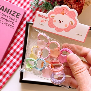 Detail view of colorful star-shaped hair ties in branded Bobbie Girl packaging bags