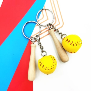 Detailed view of mini wooden baseball bat and yellow softball keychain with red stitching