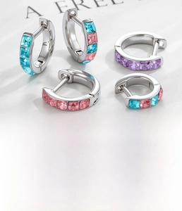 Detail showing 6mm and 8mm huggie earrings with colorful cubic zirconia inlays