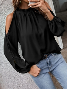 Detail of black cold-shoulder blouse with ruffled neckline and buttoned sleeves