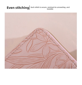 Detail of floral embossed pink leather wallet featuring precise stitching and metal zipper