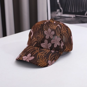 Close-up of vintage lace embroidery with golden leaves and pink floral details on the cap