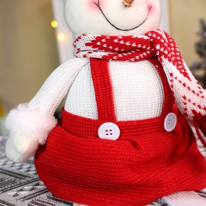 Gros plan d'un bonhomme de neige en peluche avec des textures tricotées rouges et blanches