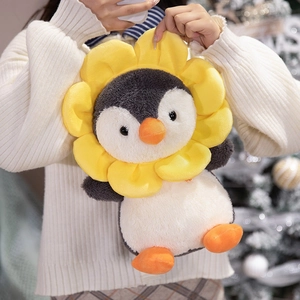Cute plush penguin doll wearing a yellow sunflower headpiece in a cozy indoor setting