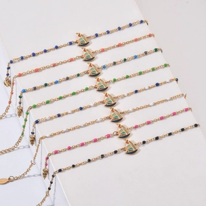 Colorful beaded stainless steel bracelets with enamel sailboat charms on a white backdrop