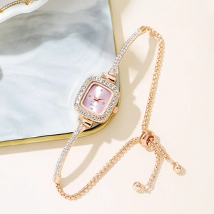 Close-up of rose gold square watch with pink dial and rhinestones on marble tray