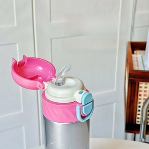 Detail view of the pink flip-top lid with transparent dual-drinking spout design