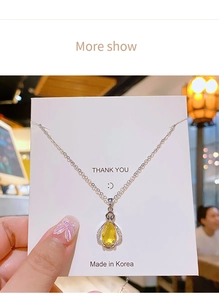 Macro shot of yellow teardrop zircon perfume bottle pendant necklace with silver chain